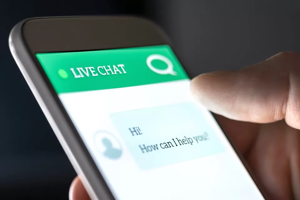View of a phone with a chatbot interface asking user how it can help them.